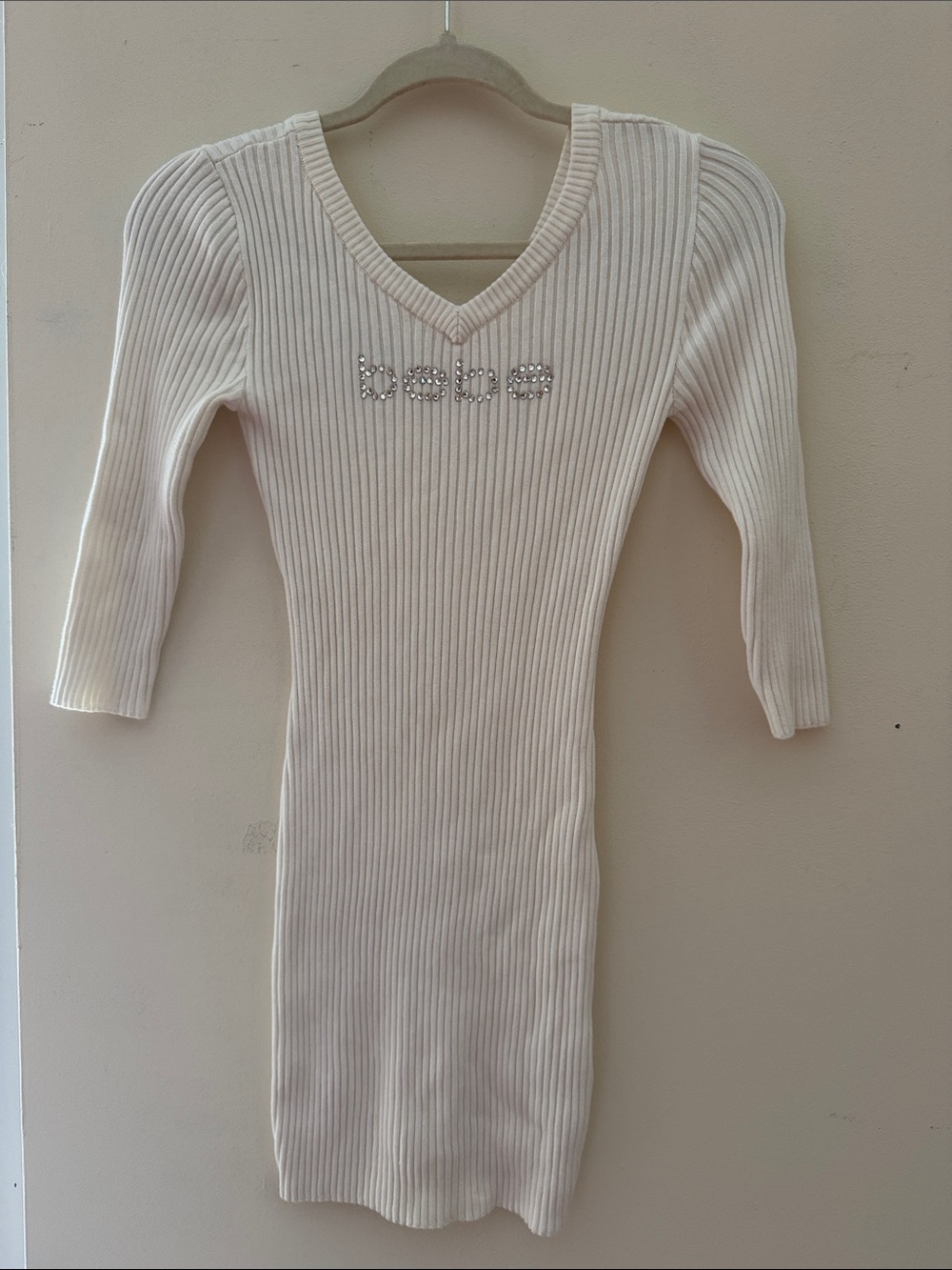 bebe Cream Ribbed V-Neck Knit Tunic with Rhinestone Logo